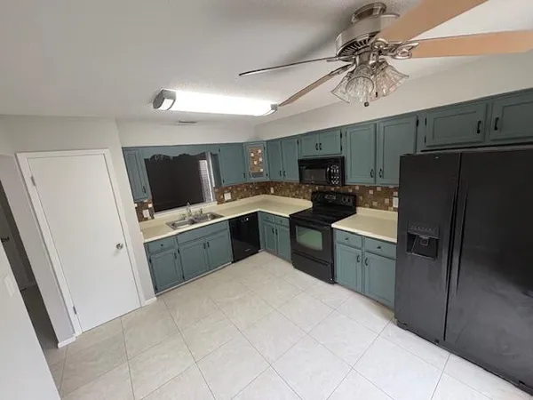 a kitchen with a refrigerator sink and wooden cabinets
