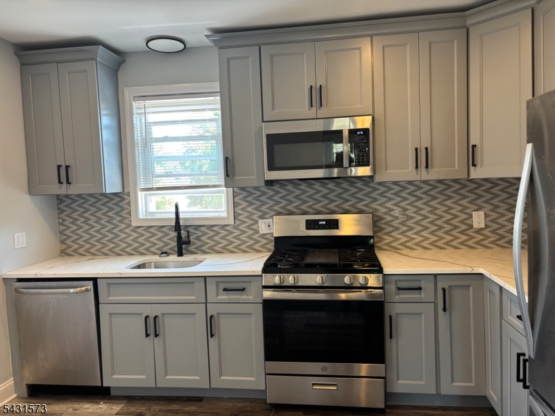 358 Woodland Road, Unit 2 Madison, NJ 07940 - Photo 4 of 50 a kitchen with granite countertop a stove sink and microwave