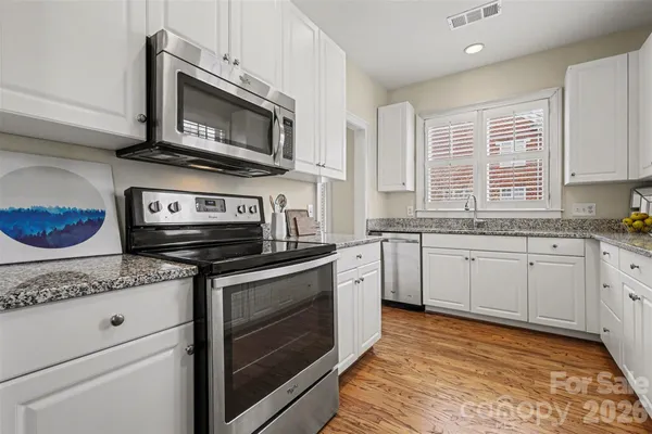 a kitchen with stainless steel appliances granite countertop a stove microwave and sink