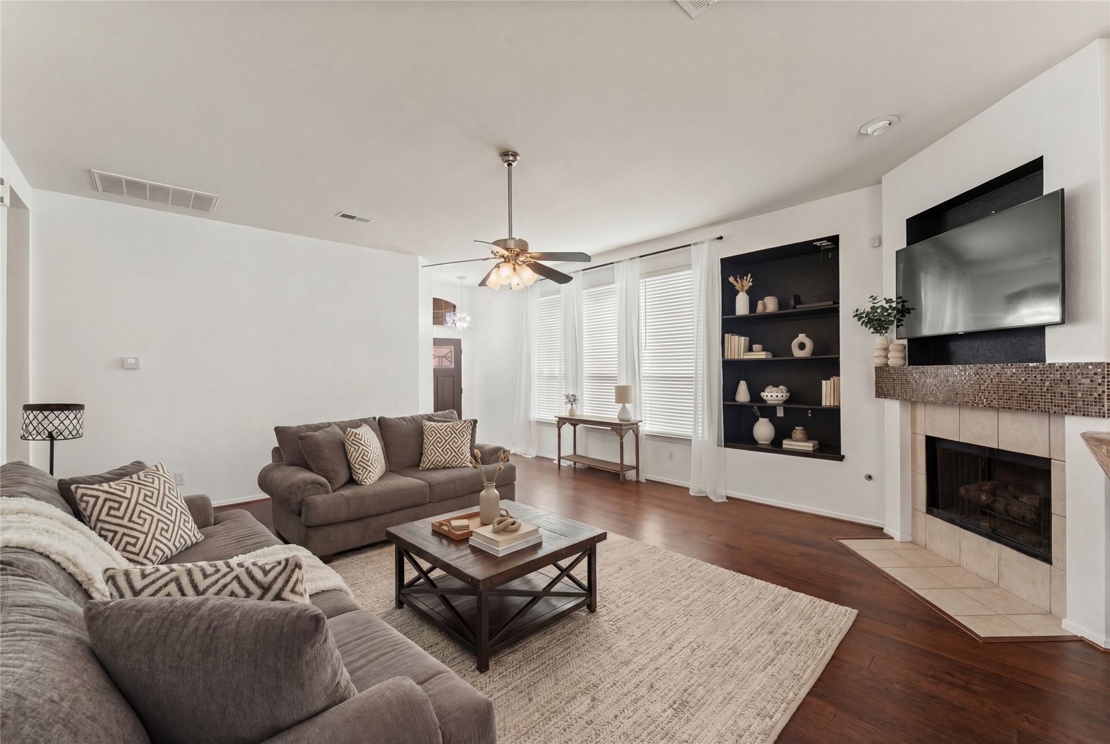 2217 Valley View Crossing Conroe, TX 77304 - Photo 6 of 24 a living room with furniture a flat screen tv and a fireplace