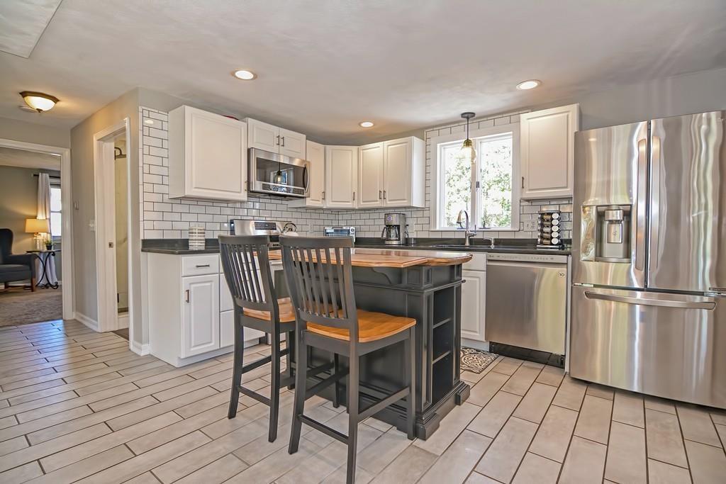 8 Edith Road Hudson, MA 01749 - Photo 4 of 26 a kitchen with stainless steel appliances granite countertop a stove top oven a sink dishwasher a refrigerator and white cabinets with wooden floor