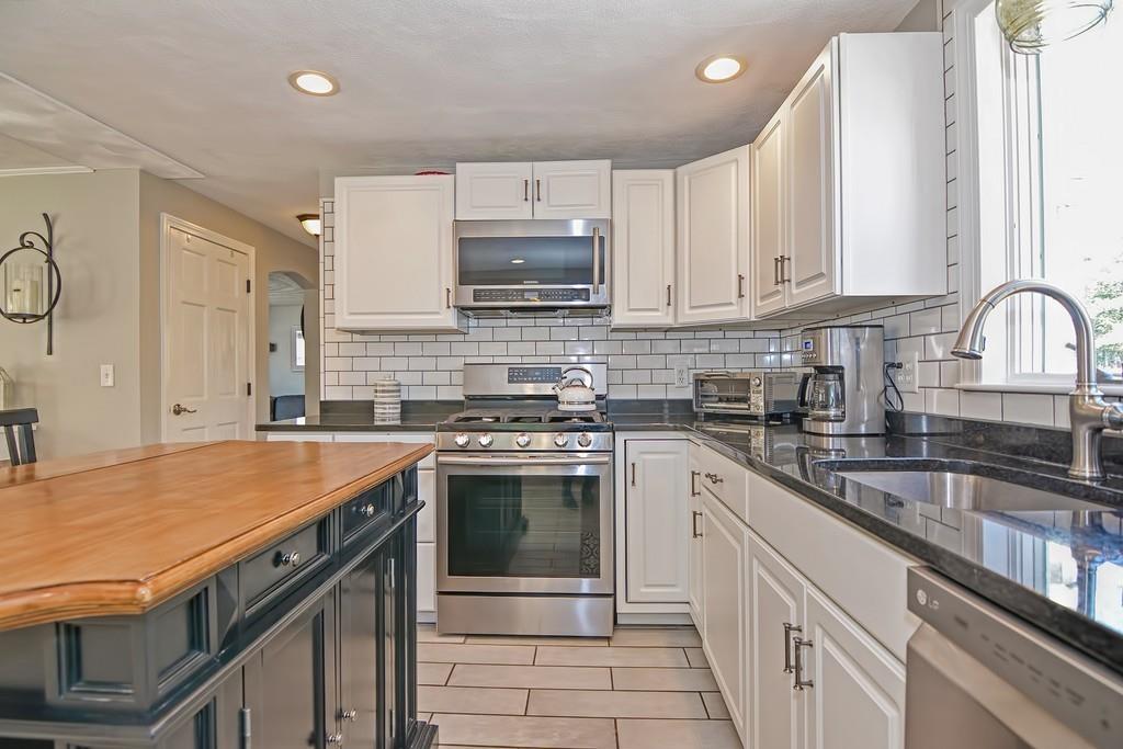 8 Edith Road Hudson, MA 01749 - Photo 5 of 26 a kitchen with stainless steel appliances granite countertop a stove sink and cabinets