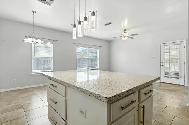 a bathroom with a granite countertop sink and chandelier