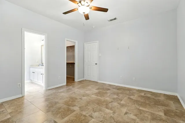 an empty room with closet and a chandelier fan