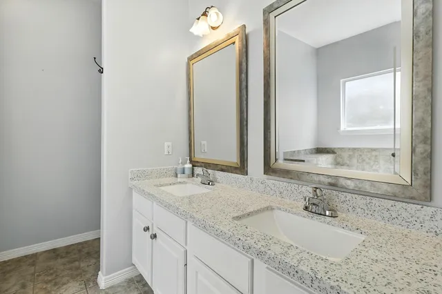 a bathroom with a granite countertop sink and a mirror