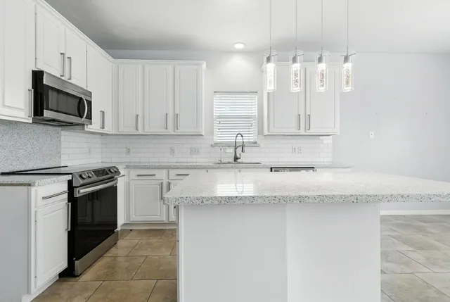 a kitchen with stainless steel appliances granite countertop a sink stove and microwave