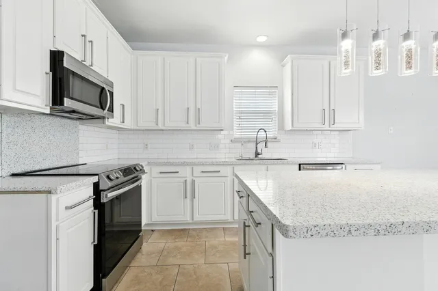 a kitchen with stainless steel appliances granite countertop a sink stove and microwave