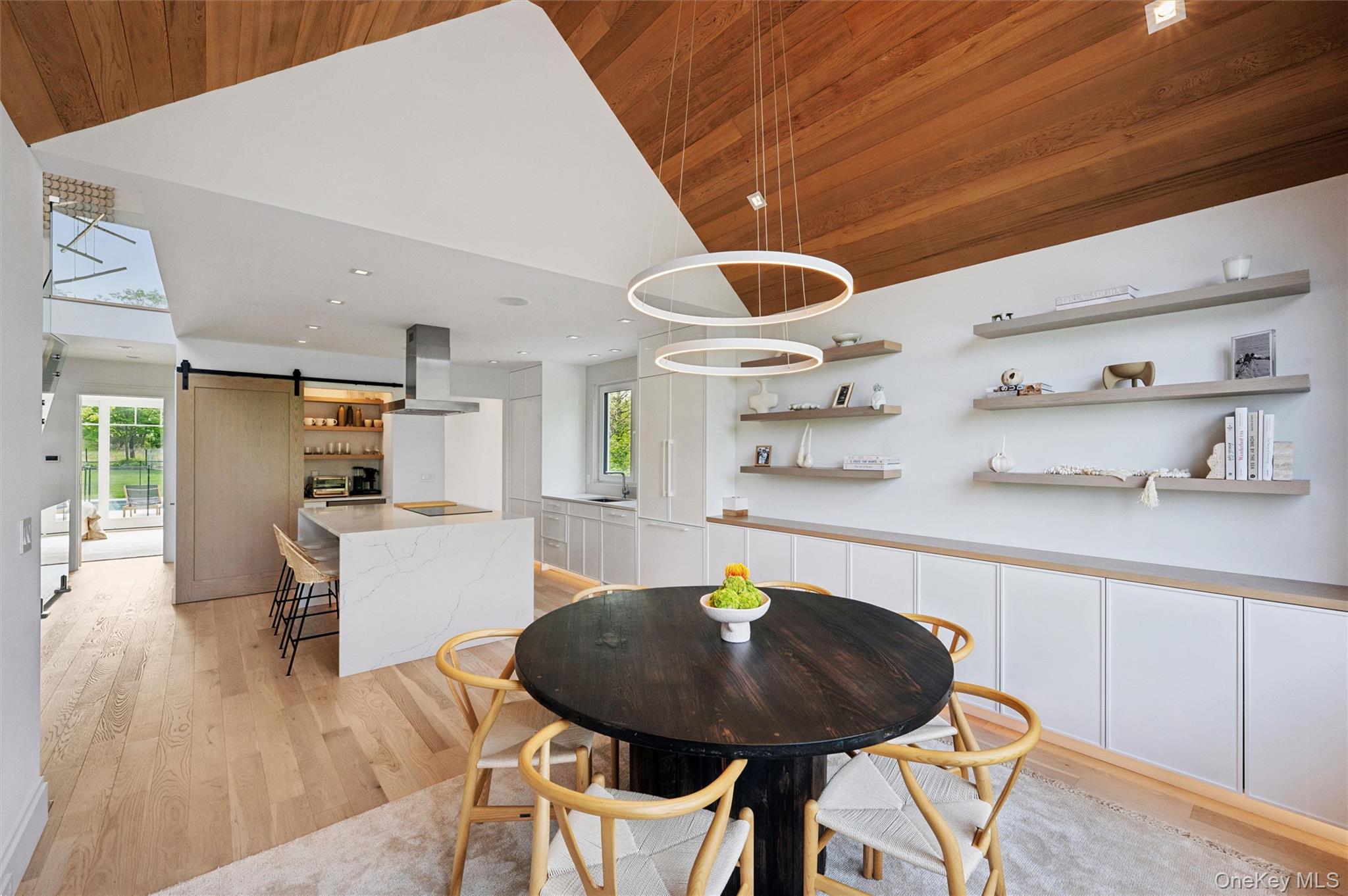 28 Canoe Place Road Hampton Bays, NY 11946 - Photo 11 of 34 a kitchen with dining table and chairs