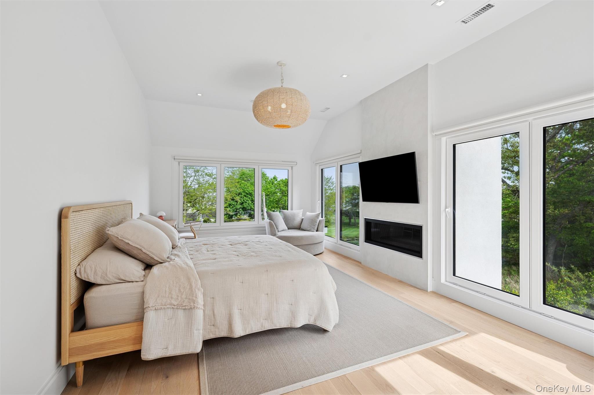 28 Canoe Place Road Hampton Bays, NY 11946 - Photo 17 of 34 a bedroom with a large bed and a flat tv screen