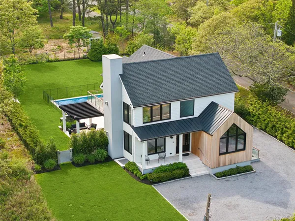 a aerial view of a house next to a big yard and large trees