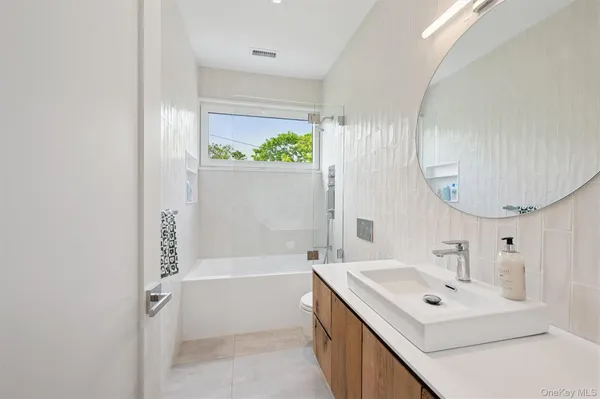 a bathroom with a bathtub a sink and a mirror