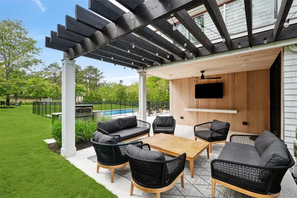 a living room with patio furniture and a garden