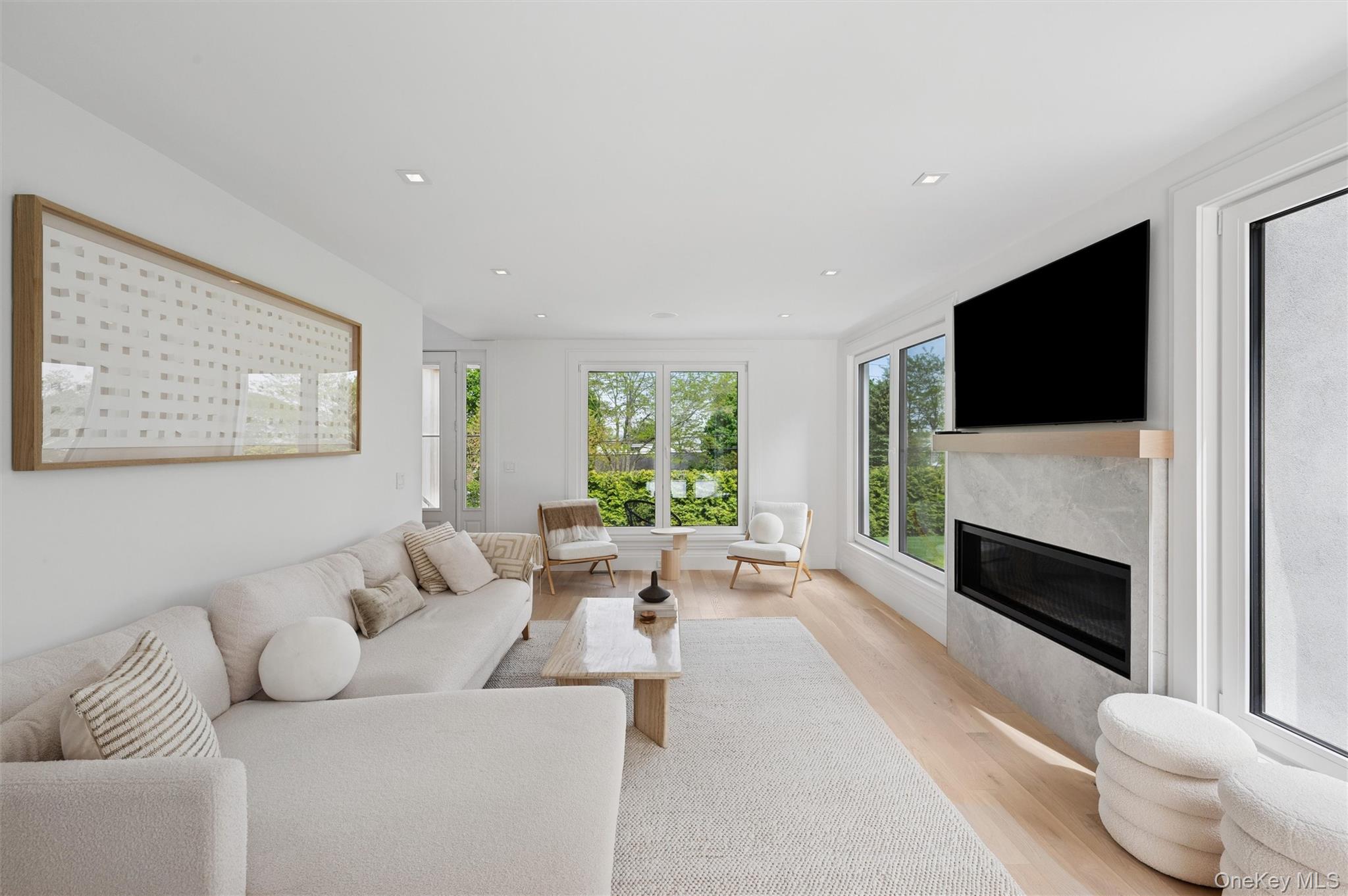 28 Canoe Place Road Hampton Bays, NY 11946 - Photo 6 of 34 a living room with furniture a flat screen tv and a fireplace