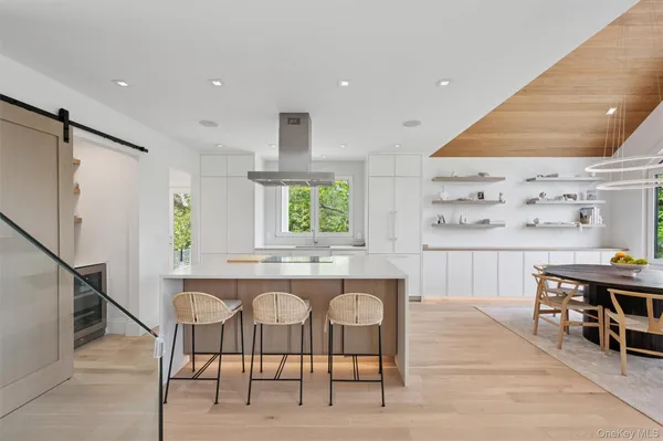 a kitchen with stainless steel appliances kitchen island granite countertop a table chairs sink and cabinets