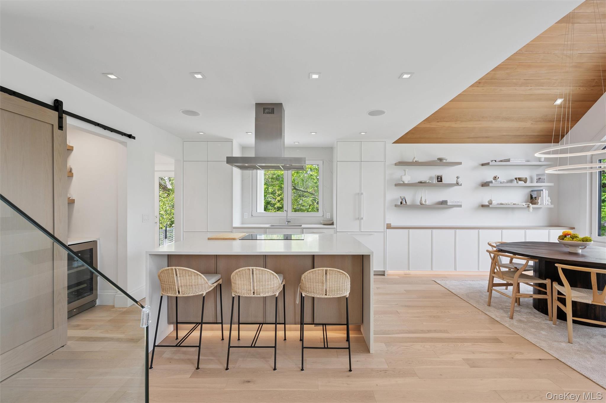 28 Canoe Place Road Hampton Bays, NY 11946 - Photo 8 of 34 a kitchen with stainless steel appliances kitchen island granite countertop a table chairs sink and cabinets