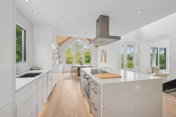 a kitchen with stainless steel appliances a sink stove and large window