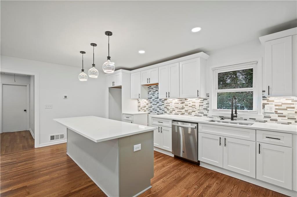 134 Normandy Drive Southwest Marietta, GA 30064 - Photo 15 of 26 a large kitchen with kitchen island a sink a stove a refrigerator and a dining table with wooden floor