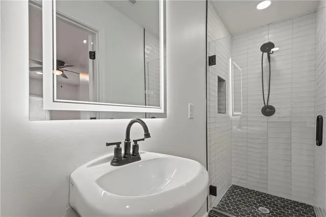 a bathroom with a sink a toilet and shower