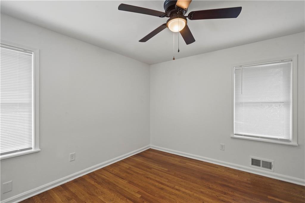 134 Normandy Drive Southwest Marietta, GA 30064 - Photo 22 of 26 an empty room with wooden floor ceiling fan and windows