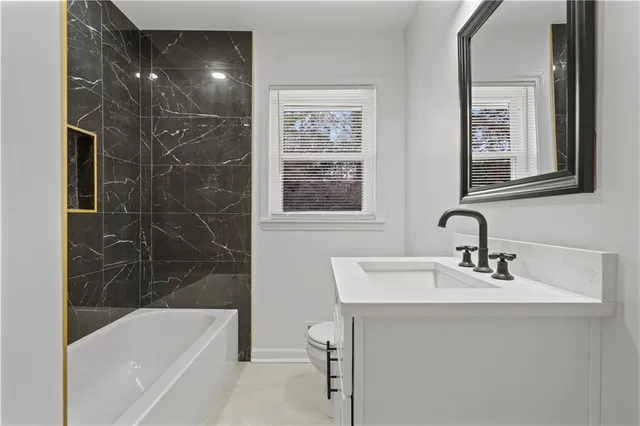 a bathroom with a sink mirror toilet and bathtub