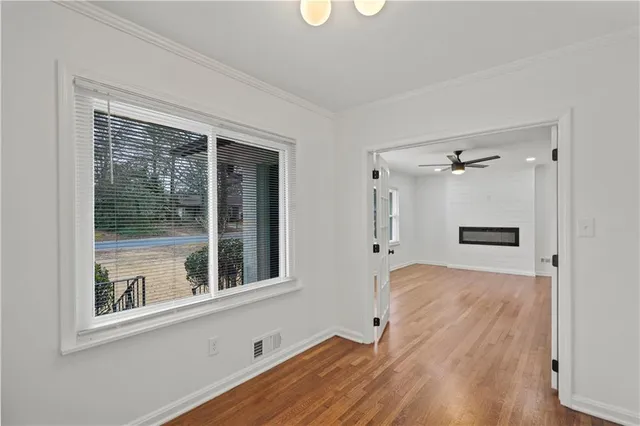 a view of a hallway with wooden floor and a cabinet