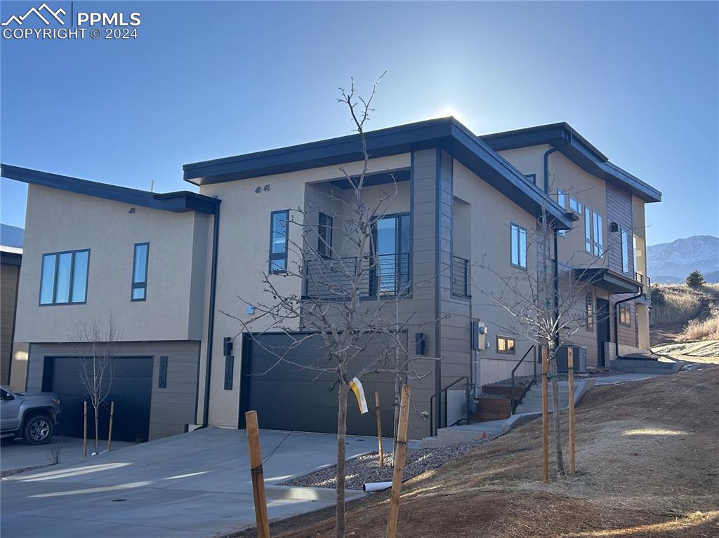 Townhome for sale on left side of building; view of front of property with a garage and a mountain view