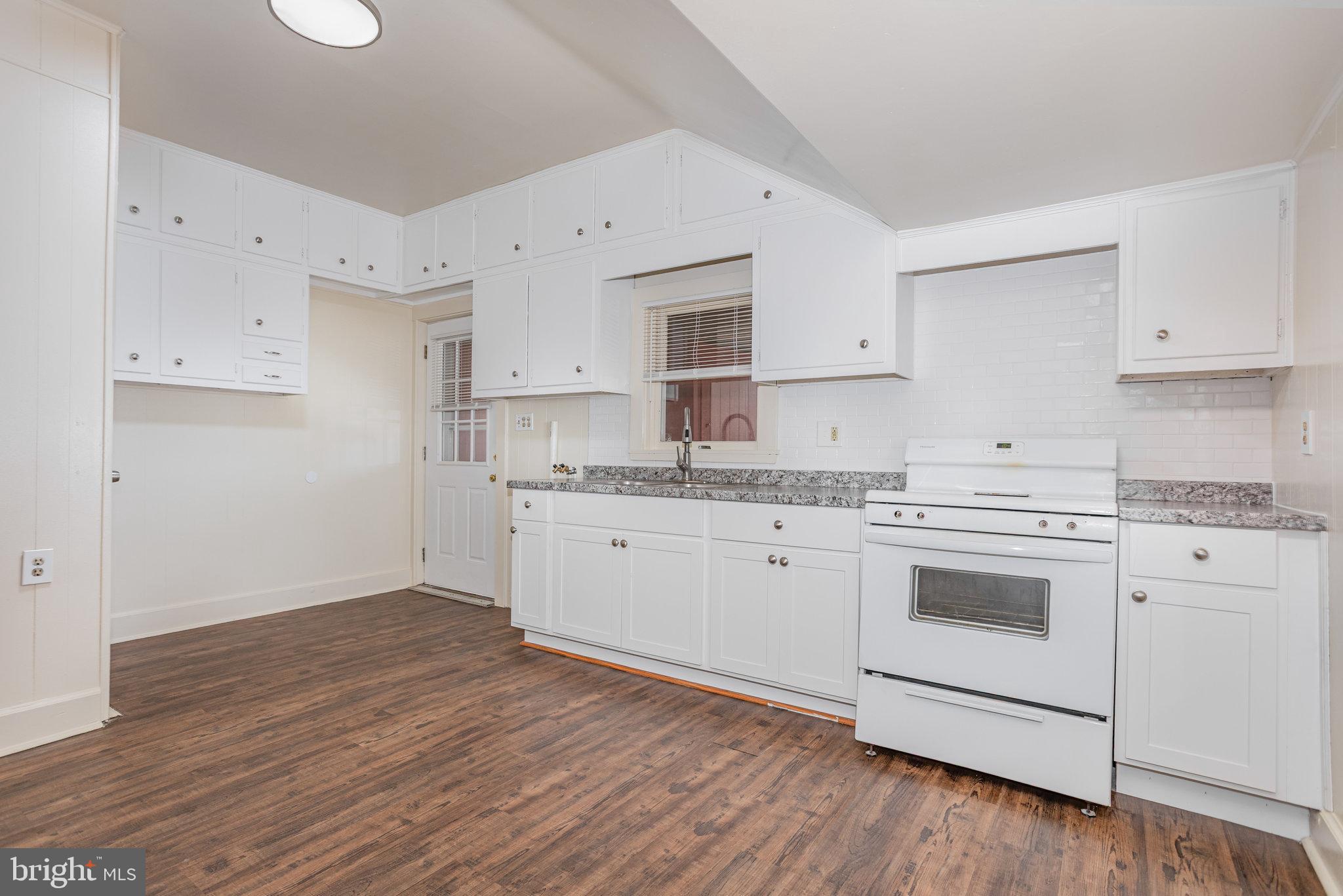 402 Spruce Street Steelton, PA 17113 - Photo 13 of 32 a kitchen with granite countertop white cabinets and white appliances with wooden floor