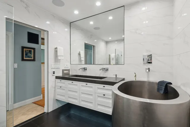 a bathroom with a granite countertop sink mirror and bathtub