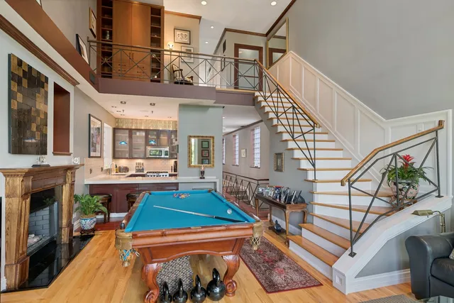 a room with lots of white furniture and a fireplace