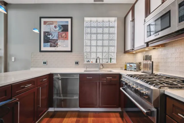 a kitchen with stainless steel appliances a sink stove and cabinets