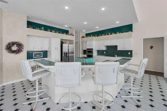 a kitchen with granite countertop a stove a sink and a refrigerator
