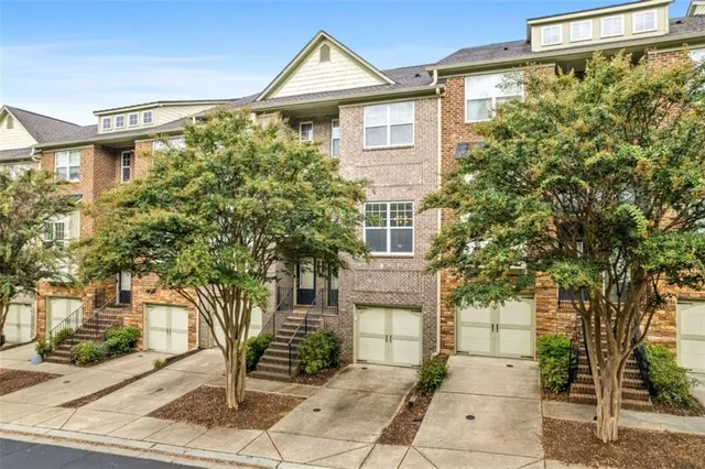 a front view of a house with a tree