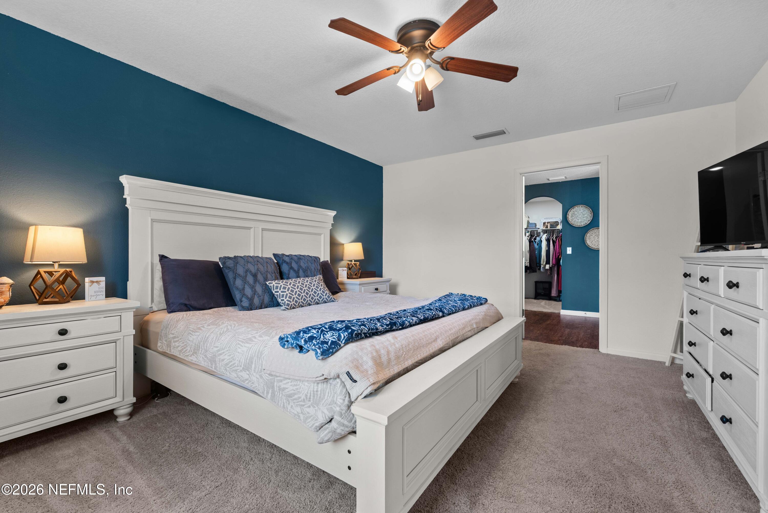 6178 Daylilly Road Macclenny, FL 32063 - Photo 16 of 29 a bedroom with a bed and a flat tv screen on dresser
