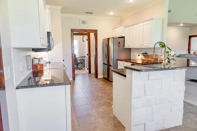 a kitchen with stainless steel appliances granite countertop a sink and a refrigerator