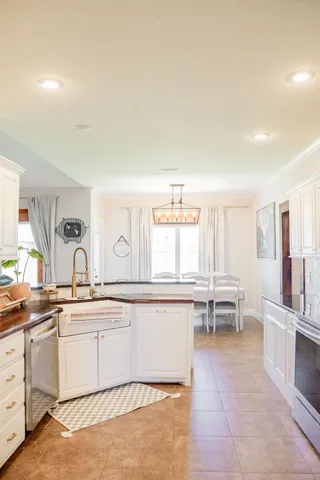 a kitchen with a sink and chairs