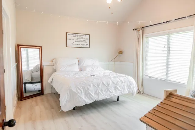 a spacious bedroom with a bed and a chandelier