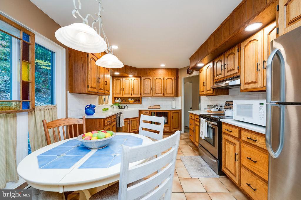 199 Deer Hill Lane Reading, PA 19607 - Photo 14 of 65 a kitchen with stainless steel appliances wooden floor dining table and chairs