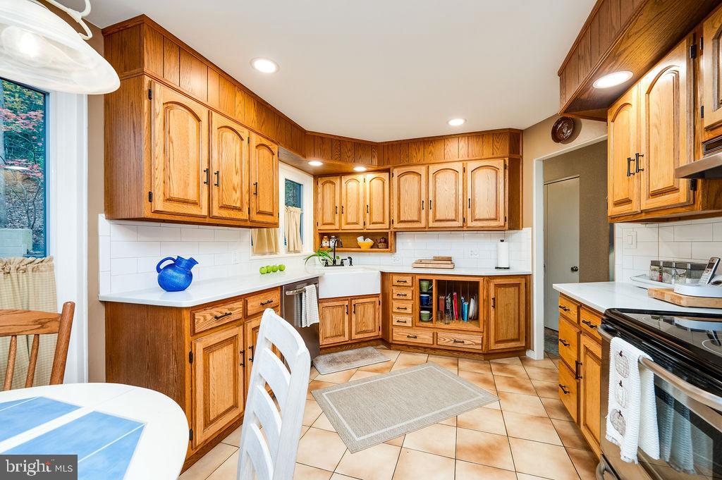 199 Deer Hill Lane Reading, PA 19607 - Photo 15 of 65 a kitchen with stainless steel appliances granite countertop a stove top oven a sink dishwasher and wooden cabinets with a dining table