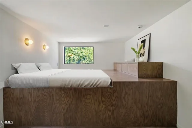 a bed sitting in a bedroom next to a window