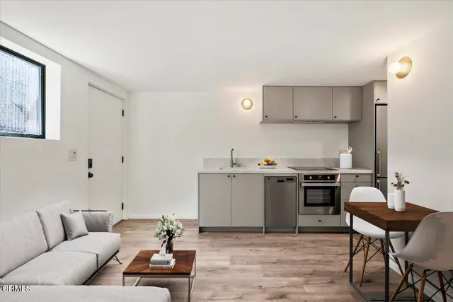 a living room with furniture and kitchen