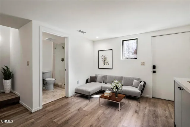a living room with furniture and a wooden floor