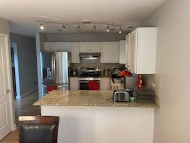 2174 Brookside Lane Aurora, IL 60502 - Photo 23 of 32 a kitchen with stainless steel appliances a stove a sink a microwave a refrigerator and cabinets