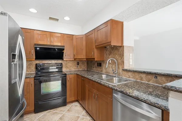a kitchen with stainless steel appliances granite countertop a sink and a stove