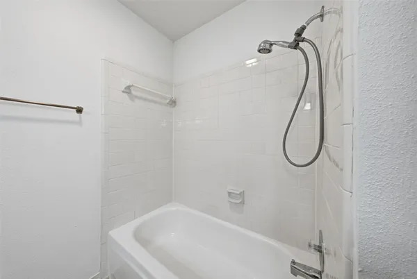 a bathroom with a bath tub with a shower