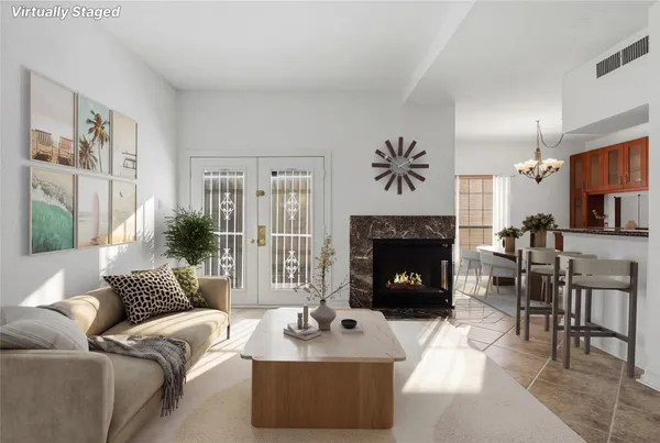 a living room with furniture a fireplace and a large window