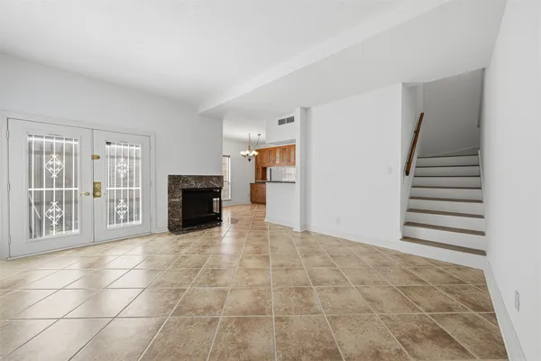 a view of an empty room with a fireplace and a window