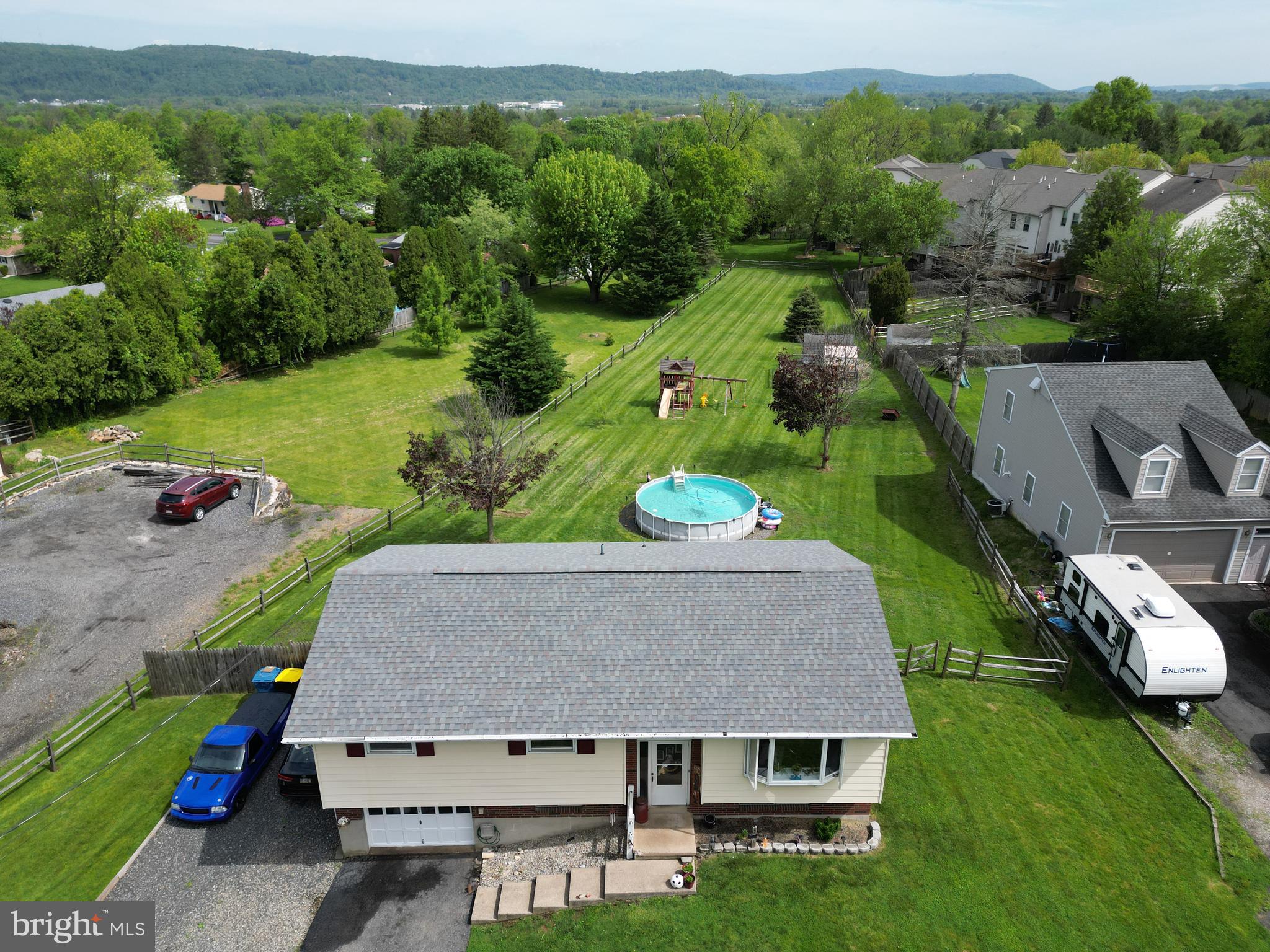 an aerial view of a house with pool garden and mountain view in back