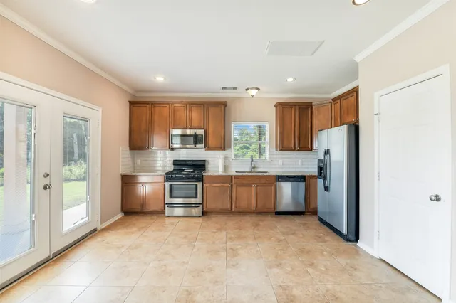 a large kitchen with a large window and stainless steel appliances