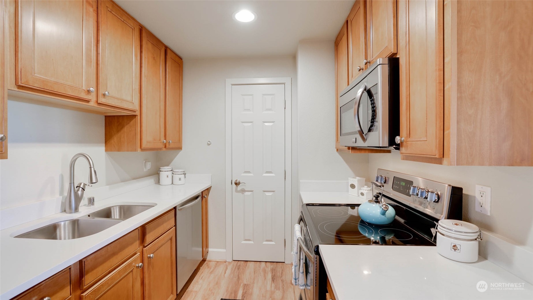 2514 57th Avenue Southwest, Unit 102 Seattle, WA 98116 - Photo 12 of 18 a kitchen with stainless steel appliances a sink stove and cabinets
