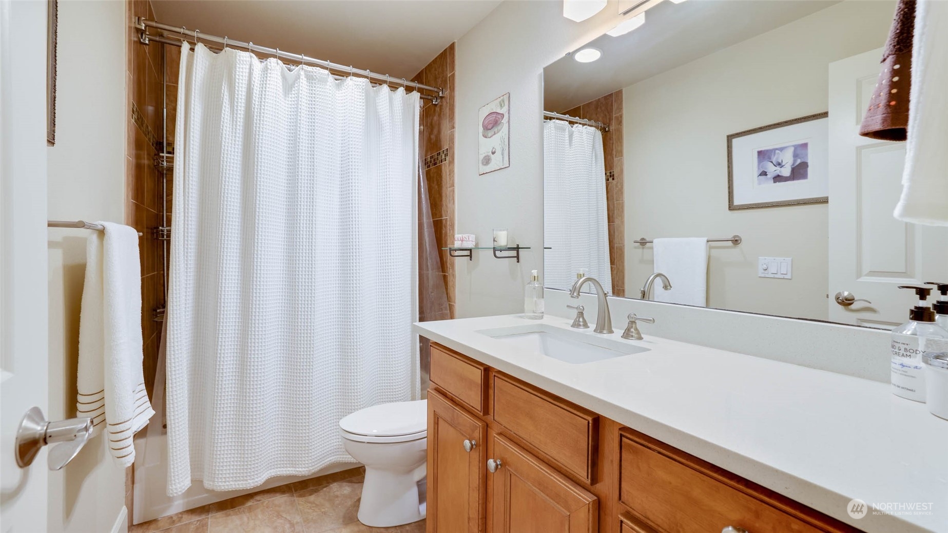 2514 57th Avenue Southwest, Unit 102 Seattle, WA 98116 - Photo 18 of 18 a bathroom with a sink a toilet and shower curtain